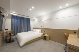 ein Hotelzimmer mit Bett und Schreibtisch in der Unterkunft Busan Hauendae Ark Blue Hotel in Busan
