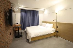 ein Hotelzimmer mit Bett und Fernseher in der Unterkunft Busan Hauendae Ark Blue Hotel in Busan