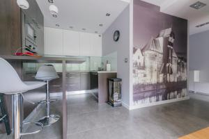 a kitchen with a table and chairs in a room at Pohulanka Luxury in Gdańsk