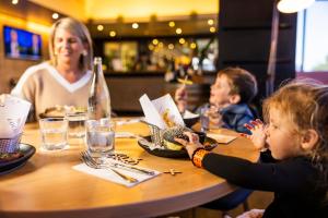 a group of children sitting at a table eating food at voco Brisbane City Centre by IHG in Brisbane
