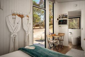 a room with a bedroom with a table and a window at Womburra Vineyard Tiny Stay by Tiny Away in Redbank
