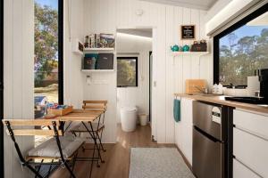 a kitchen with a table and chairs in a tiny house at Womburra Vineyard Tiny Stay by Tiny Away in Redbank