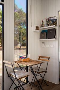 a table and chairs in a room with a window at Womburra Vineyard Tiny Stay by Tiny Away in Redbank