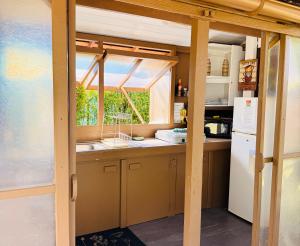 a kitchen with a window and a refrigerator at Fare Miti Ora Moorea - Bungalow mitoyen in Hauru
