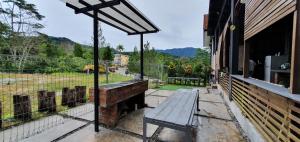 a wooden bench sitting on the porch of a building at D Pine Villa in Bukit Tinggi