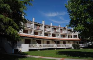 a large white building with balconies and a yard at Residence Selenis in Caorle