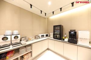 a kitchen with white cabinets and white appliances at Hotel Signature Gwangju in Gwangju