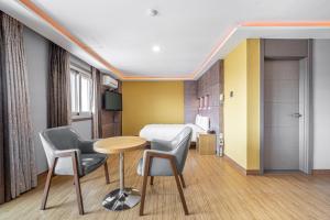 a hotel room with a bed and a table and chairs at Hotel memory Jumunjin- Welcome drink provided in Gangneung