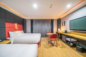 a hotel room with two beds and a flat screen tv at Hotel memory Jumunjin- Welcome drink provided in Gangneung