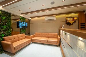 a waiting room with two leather couches and a tv at Hotel Royal Inn in Thane +39 photos