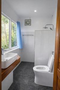 a white bathroom with a toilet and a sink at My village river side in Nongkhiaw