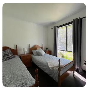 two beds in a bedroom with a window at Private Accommodation at the Megaranch in Nyora