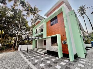 a house with green and orange at hello 6 cliff stay varkalacliff - cozy rooms , couple friendly ,family ,group rooms in Varkala