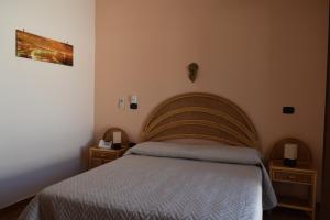 una camera con un letto e due comodini di Bed &Breakfast Pinetamare a Castel Volturno