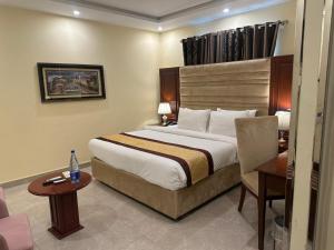 a hotel room with a large bed and a table at City Oasis Boutique Hotel in Lahore +42 photos