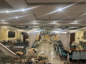 a banquet hall with tables and chairs and flowers at City Oasis Boutique Hotel in Lahore