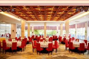 a banquet hall with tables and red chairs at Sai Gon Dong Ha Hotel - a member of Saigontourist Group in Quang Tri