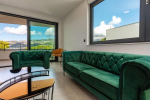 a living room with a green couch and windows at Korcula Hill in Korčula