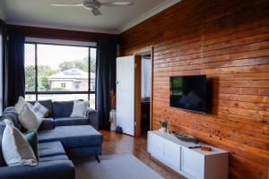a living room with a wooden wall with a tv at Spacious 3-Bed Home in Central Tenterfield in Tenterfield