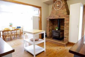 a living room with a brick fireplace and a table at Spacious 3-Bed Home in Central Tenterfield in Tenterfield