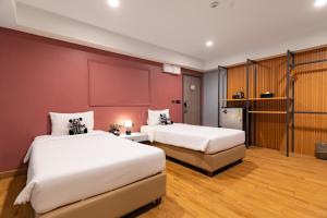 two beds in a hotel room with red walls at Lima Hotel in Phra Nakhon Si Ayutthaya +56 photos