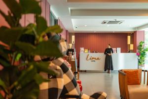 a woman standing in front of a counter in a store at Lima Hotel in Phra Nakhon Si Ayutthaya