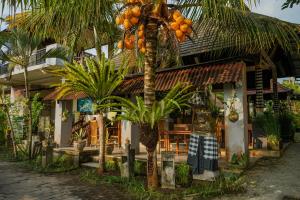 a building with a palm tree in front of it at Villa JJ and Spa Ubud in Ubud