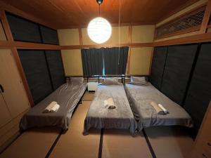 two beds in a small room with windows at ほしのすみか in Nikko