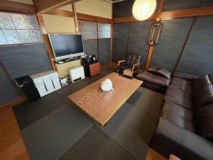 a living room with a couch and a tv at ほしのすみか in Nikko