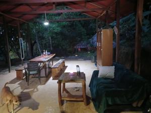 a patio with a table and a couch and a dog at Private jungle accommodation with waterfall in Minca