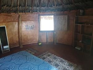 an empty room with a bed and a window at Private jungle accommodation with waterfall in Minca