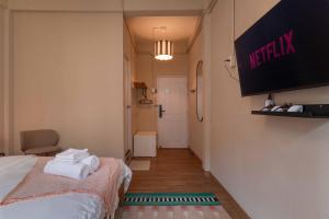 ein Zimmer mit einem Bett und einem Fernseher an der Wand in der Unterkunft Walk2BTS, KingBed, FastWiFi, FreeLaundry, Netflix in Klong Toi