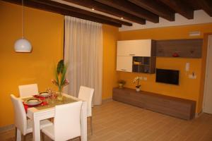 a dining room with a table and white chairs at Aretusa Apartments in Siracusa