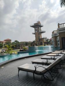 a row of chaise lounges next to a swimming pool at Vaikunth Village Resort in Raipur +32 photos