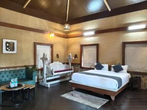 a bedroom with a king sized bed and a couch at Vaikunth Village Resort in Raipur