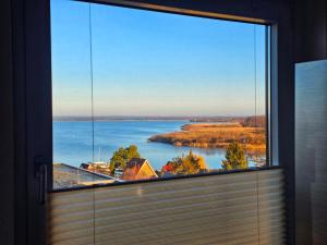 a large window with a view of a river at Ferienwohnung Sunset - Traumhafter Seeblick & Sauna in Steinhude in Wunstorf