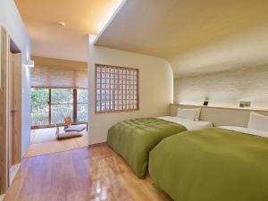 two beds in a room with a window at Chikurakutei in Minami Aso +62 photos
