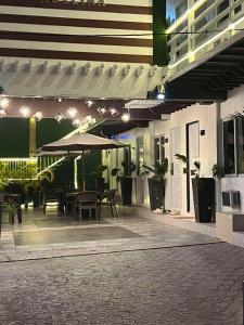 an outdoor patio with a table and an umbrella at Hotel Adelina Balanga City Bataan in Balanga