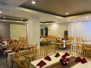 a banquet hall with tables and chairs with red napkins at Hotel Adelina Balanga City Bataan in Balanga +44 photos