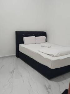 a bed sitting in a room with marble floors at H Sri Sayang Hotel Sdn Bhd in Skudai