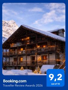 a building covered in snow with the words travel review awards at Casalpina Cozy chalet in Gressoney-la-Trinité +11 photos