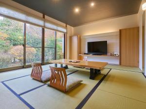 a living room with a wooden table and two chairs at Chikurakutei in Minami Aso