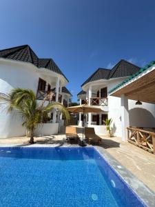 a swimming pool in front of a villa at Jumbo Resort in Paje