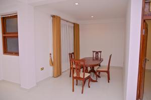 a dining room with a wooden table and chairs at Windsor in Kandy +6 photos