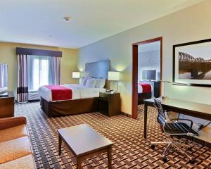 a hotel room with a bed and a desk at Comfort Suites Uniontown in Uniontown