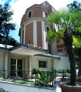 um edifício com uma palmeira em frente em Hotel Delle Muse em Roma