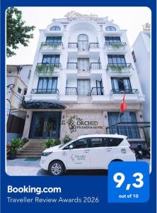 a white car parked in front of a building at The ORCHID PREMIUM Hotel in Hue