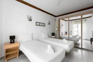 two beds in a room with a television and a bedroom at Benny Fañabé - 2 Bed and Loft Apartment, AC, Pool & Parking in Adeje +15 photos