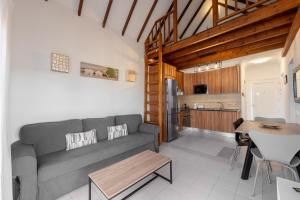 a living room with a couch and a table and a kitchen at Benny Fañabé - 2 Bed and Loft Apartment, AC, Pool & Parking in Adeje