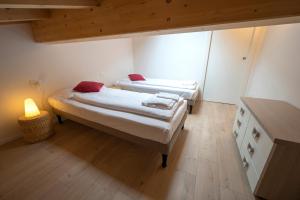two beds in a small room with a lamp at Appartamento Bastione in Riva del Garda